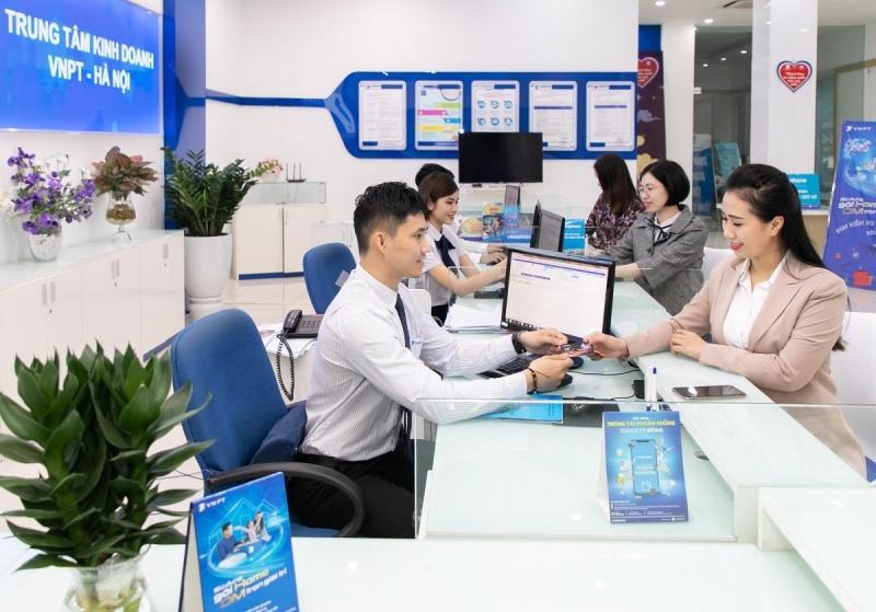 Khách hàng đến quầy giao dịch để được nhân viên hỗ trợ nạp tiền VinaPhone trả trước
